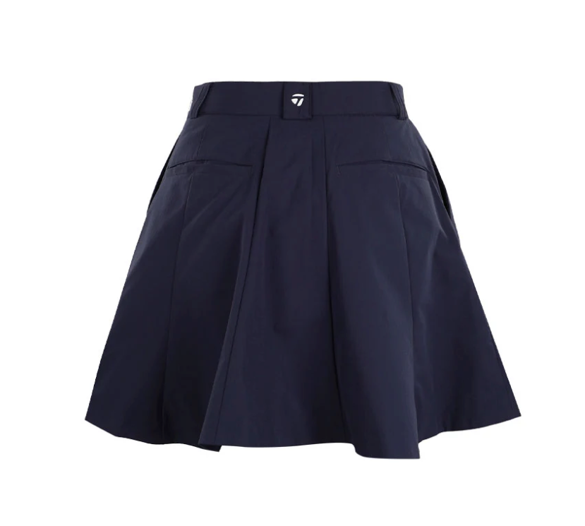 TaylorMade women's dark navy pleated golf skort with back welt pockets and a white logo on the rear belt loop.
